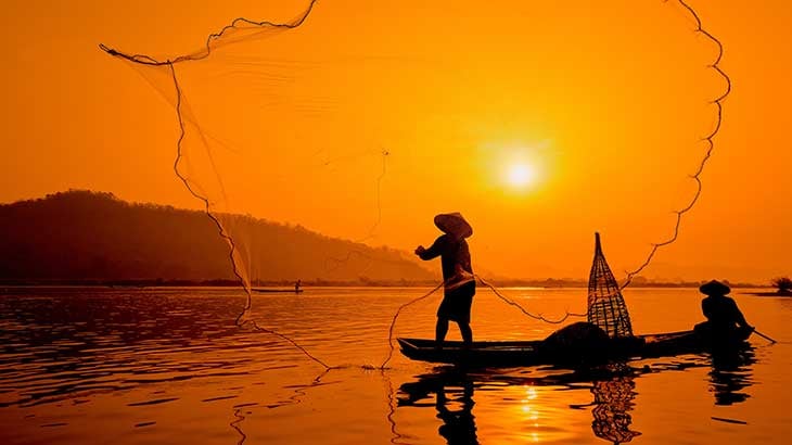 Two-men fishing on the delta casting a large net